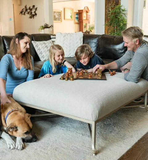 family playing chess in the living room